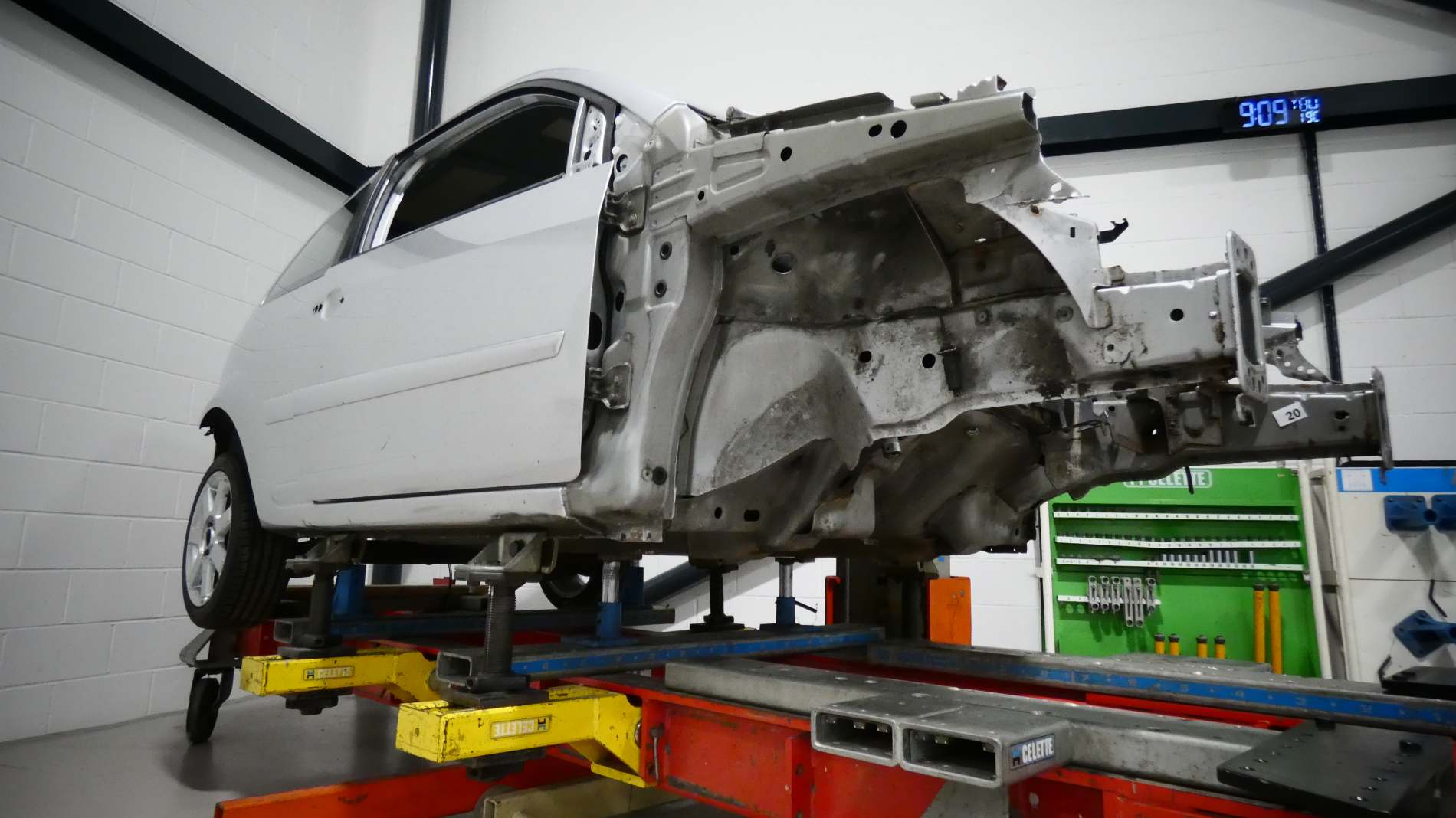 White car on a job being repaired by a panel technician